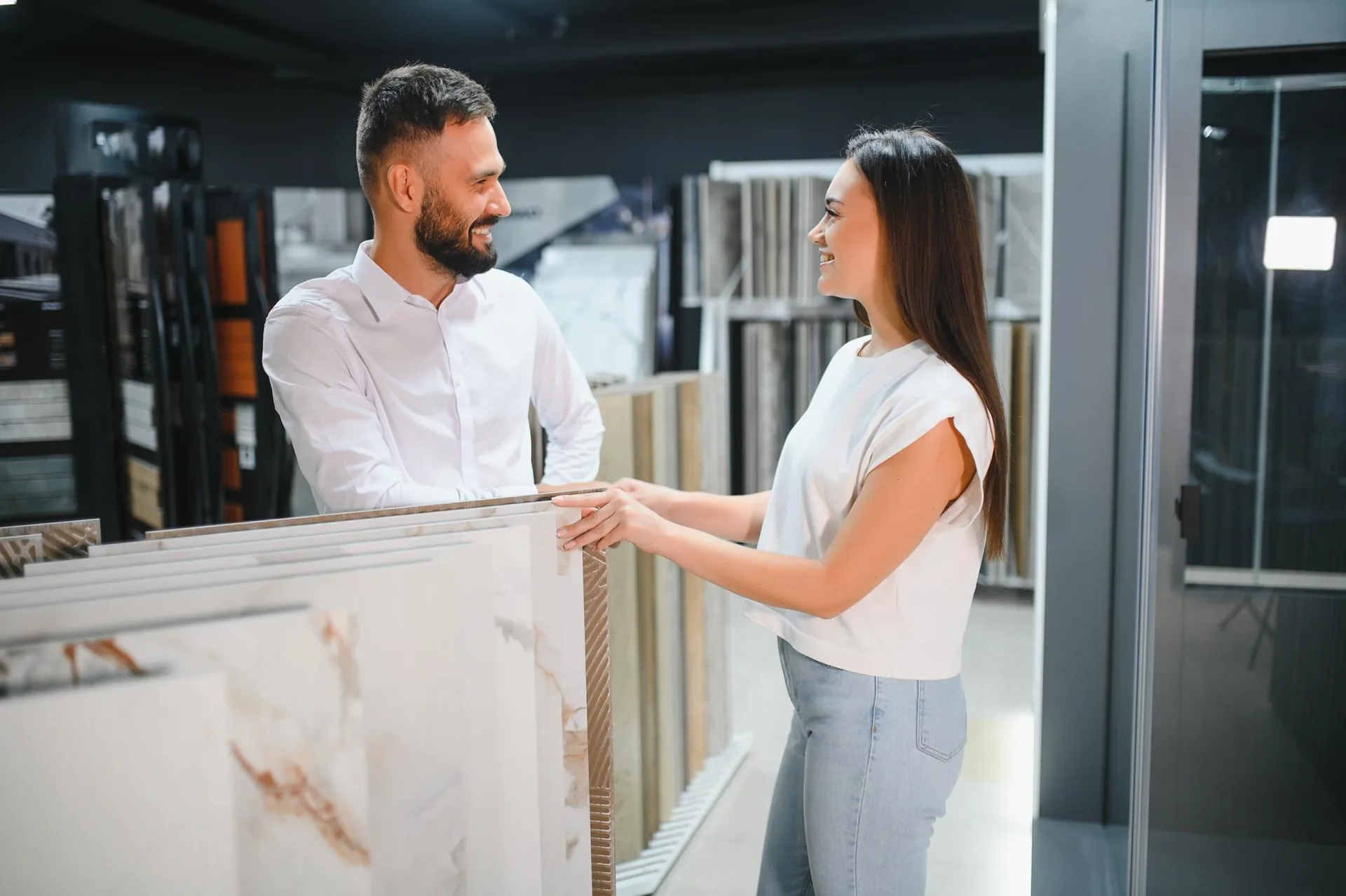 Donna e consulente che scelgono piastrelle in uno showroom di materiali per ristrutturazione