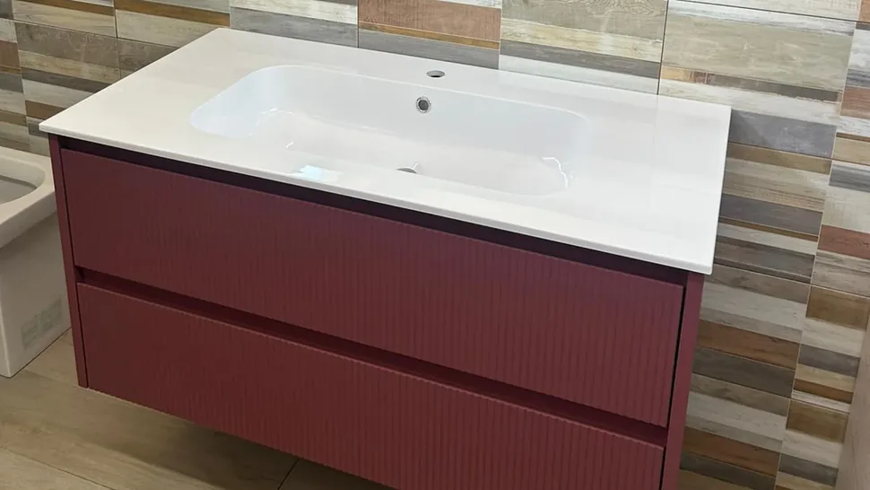 Mobile bagno Vica rosso corallo con lavabo in resina bianco lucido in showroom a Palermo
