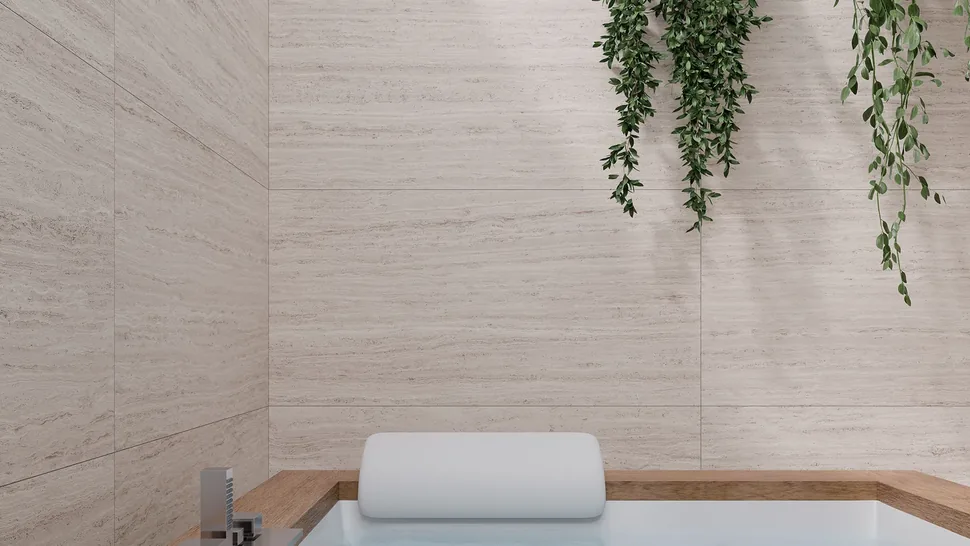 Gres effetto travertino Olimpo Avorio 60x120 posato a parete in un bagno con vasca da incasso
