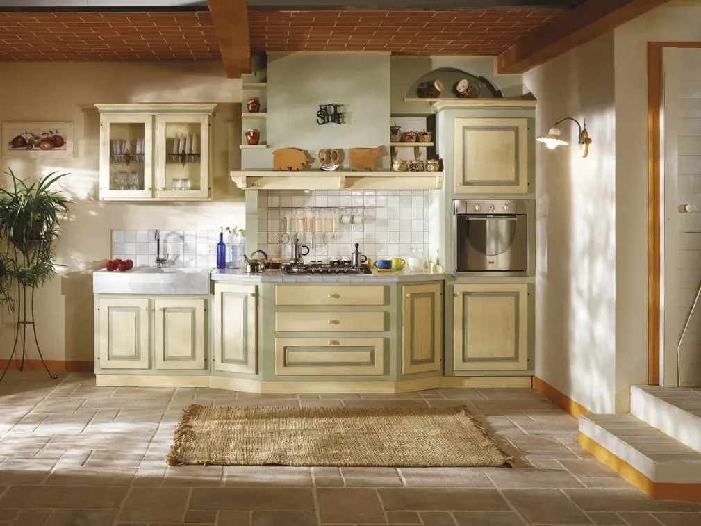 Cucina in muratura in stile rustico con ante color crema, cappa in muratura e pavimento in piastrelle