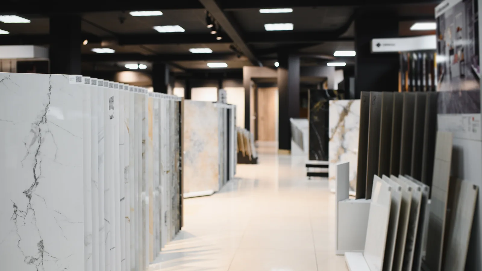 Come scegliere le piastrelle per il bagno e per ogni ambiente, lastre di gres porcellanato di grande formato esposte sugli espositori di uno showroom