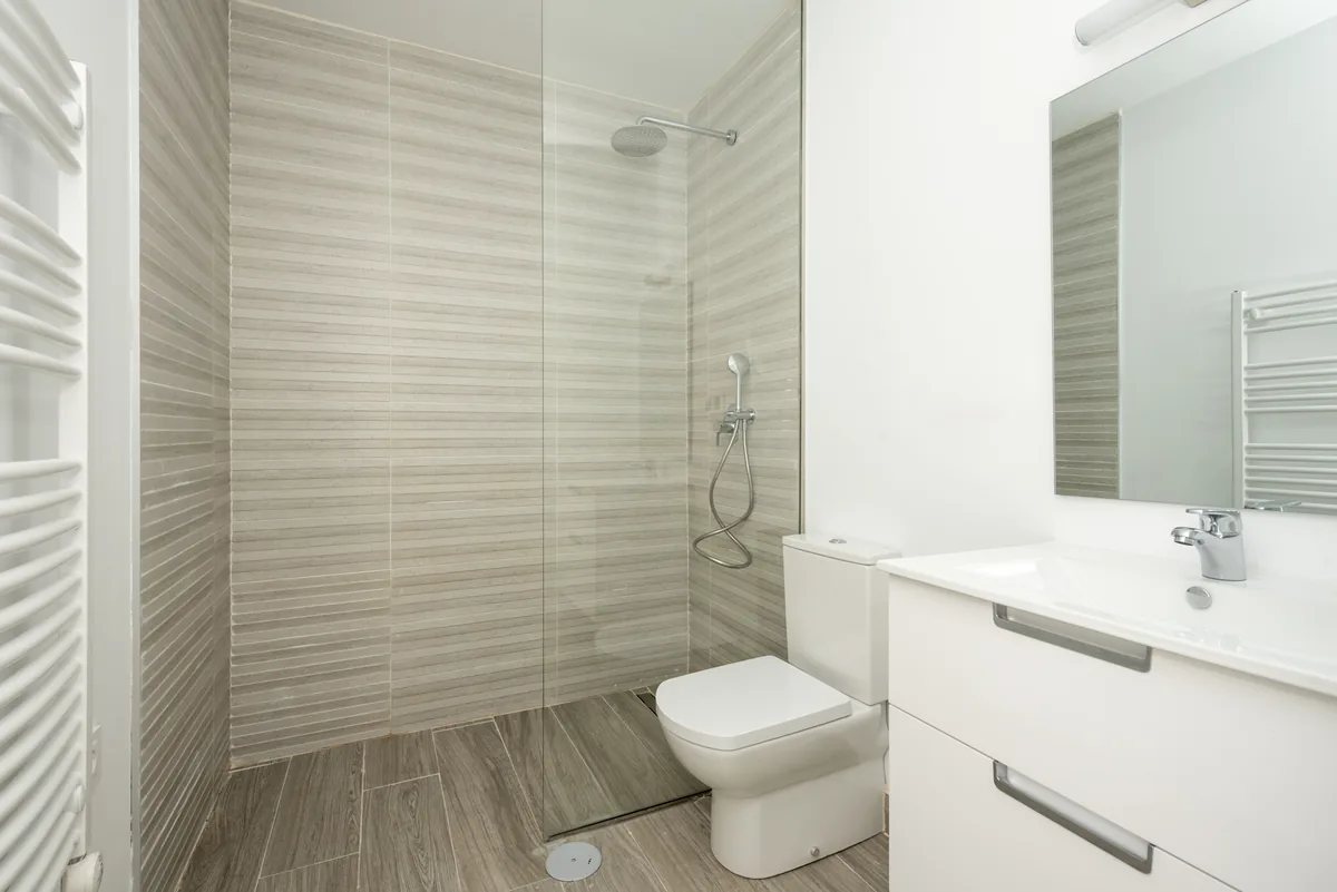 Come ristrutturare un bagno con budget ridotto Bagno moderno con pavimento in gres porcellanato effetto legno e doccia walk-in